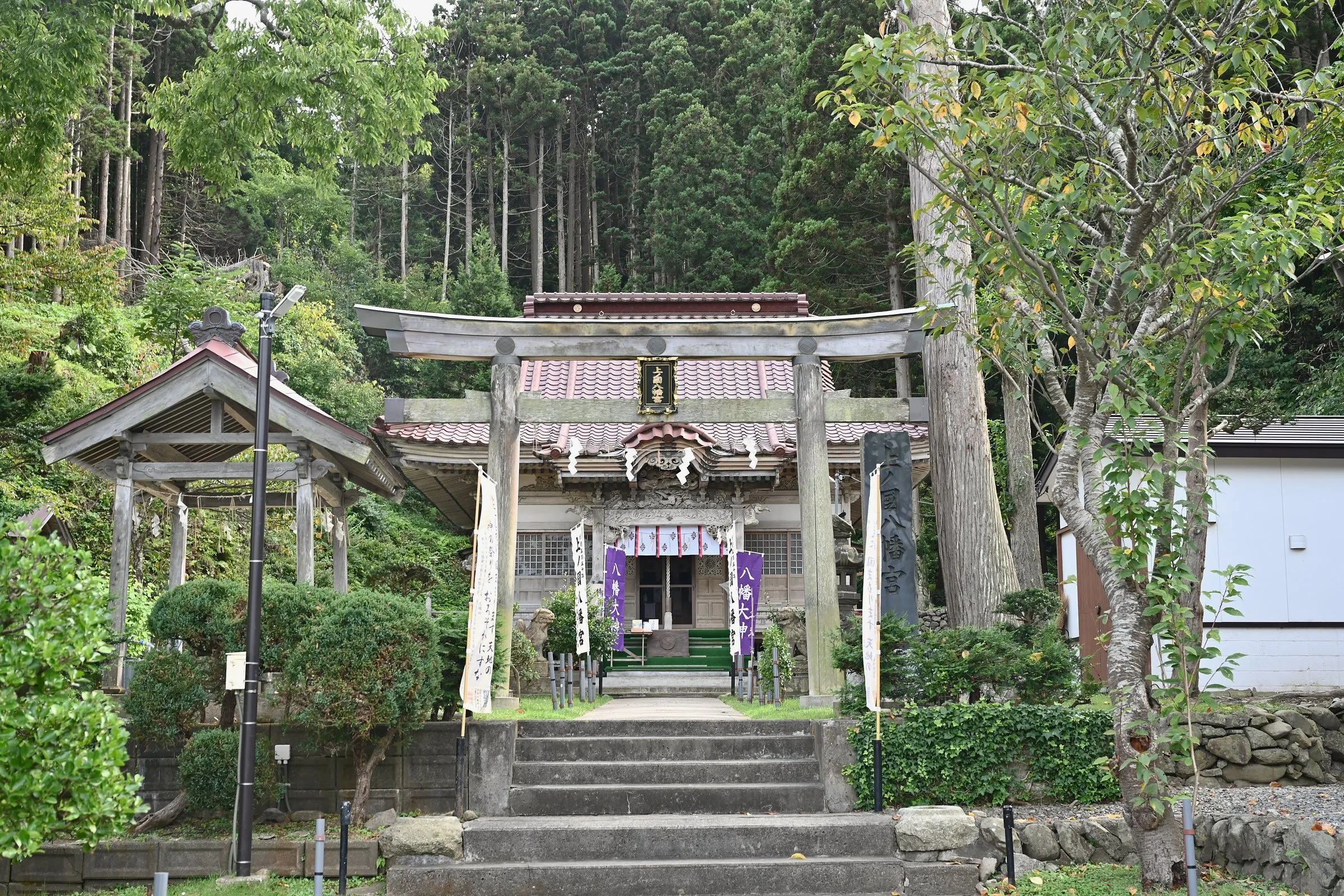 A shrine hall beyond a torii gate and stone steps